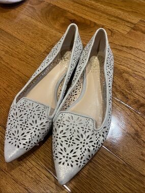 Vince Camuto Pointed Laser-Cut Flats in metallic Light Grayish taupe.